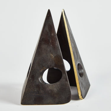Pair of brass triangle-shaped bookends on a light gray background