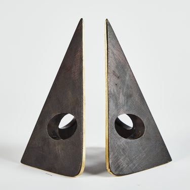 Two triangular metal bookends on a light gray background