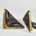 Two brass bookends on a white background
