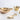 Set of gold decorative items including a bowl, crown, bell, and hand-shaped object on a white background