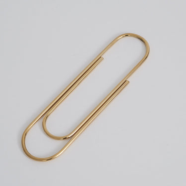 Gold paper clip on a light gray background