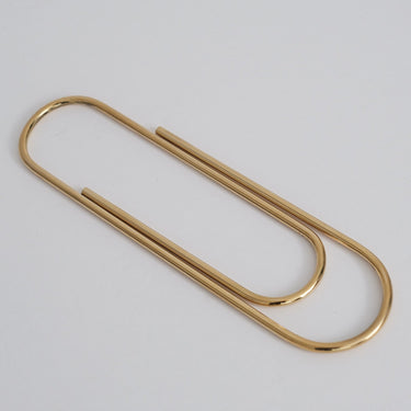 Gold paper clip on a light gray background