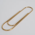 Gold paper clip on a light gray background