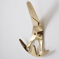 Gold-colored wall hook on a white background