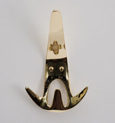 polished brass wall hook front view on a light gray background