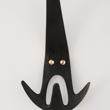 patinated brass wall hook with gold accents on a white background