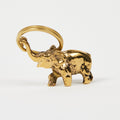 Gold elephant charm on a white background