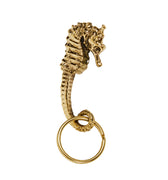 Gold seahorse-shaped keychain on a white background