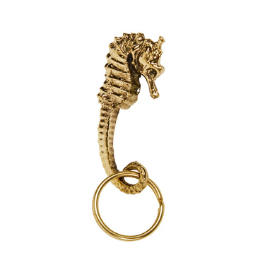 Gold seahorse-shaped keychain on a white background