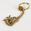 Gold keychain with a detailed design on a white background