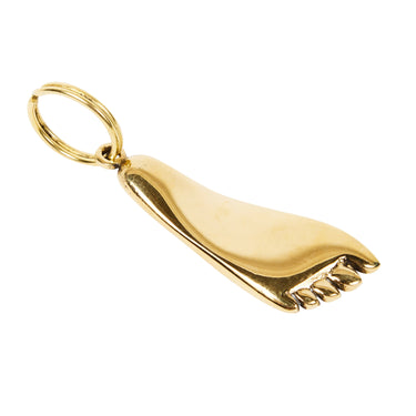 Gold foot-shaped pendant on a white background