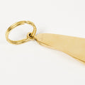 Gold foot-shaped keychain on a white background