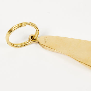 Gold foot-shaped keychain on a white background