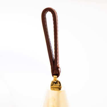 Small bell with a brown handle on a white background