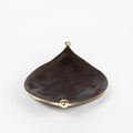 Black leaf-shaped dish with gold accents on a white background