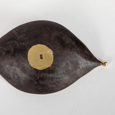 dish leaf-shaped with a gold center on a white background