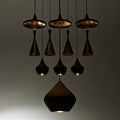 Modern tom dixon pendants on display with gold and black design on a neutral background