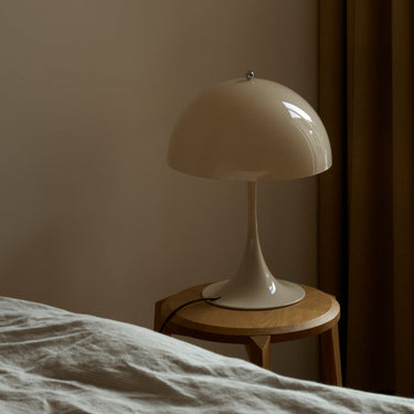 Beige table lamp on a wooden side table against a beige wall scandinavian neutral bedroom inspo.