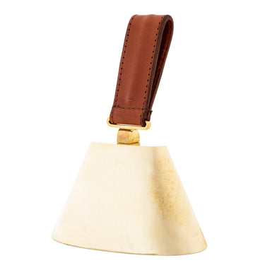 decorate and functional Brass cowbell with a brown leather handle on a white background