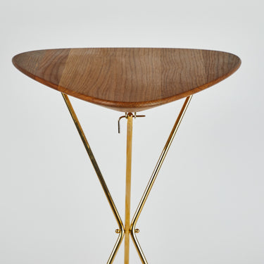 Wooden table with gold metal legs on a light gray background