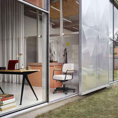 jean prouve residence featuring his furniture with large glass walls, desk, and chair.
