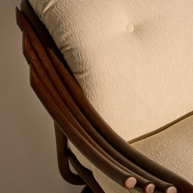 Close-up of a chair with wooden armrests and beige cushioned seat.