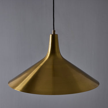 Gold pendant light against a gray background