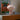 Striped lamp on a shelf with a framed poster in the background