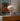 Striped lamp on a shelf with a framed poster in the background