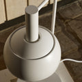 White Finn Juhl lamp on a wooden surface with a blurred background