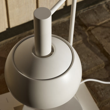 White Finn Juhl lamp on a wooden surface with a blurred background