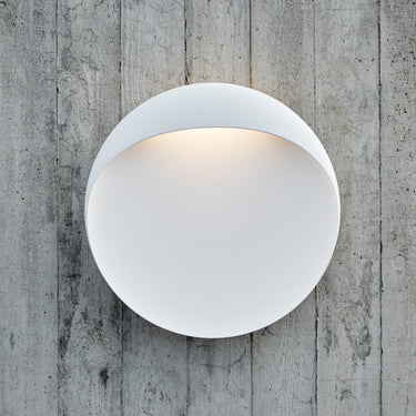 Flindt metal Round oudoor white wall light fixture on a textured concrete wall