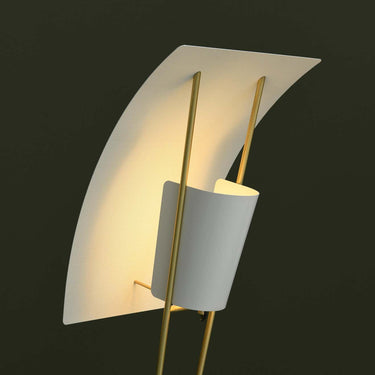 Modern wall light fixture with white shade and gold accents on a dark background