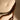 Close-up of a wooden chair with a white cushion on a plain background