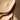 Close-up of a wooden chair with a white cushion on a plain background