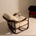 Rattan chair with beige cushions on a neutral background