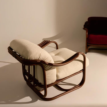 Rattan chair with beige cushions on a neutral background