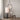 Floor lamp with a textured base next to a chair in a room with decorative wall paneling.
