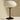 Table lamp with a white shade and black base on a neutral background