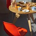 Dining table with food and drinks, surrounded by red chairs in a modern setting.