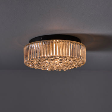 Ceiling light fixture with ribbed glass design on a dark background