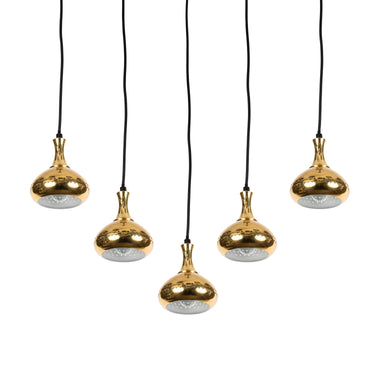 Five gold pendant lights with black cords on a white background
