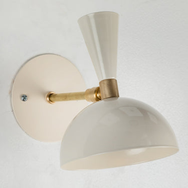 Wall-mounted ivory white light fixture with beige and gold design on a light gray background for Two Enlighten