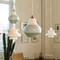 Modern geometric cirque and doo-wop white pendant lights hanging in a room with framed pictures on the wall.