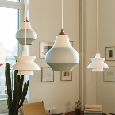 Modern geometric cirque and doo-wop white pendant lights hanging in a room with framed pictures on the wall.