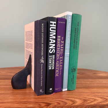 Stack of books on a wooden surface with a gray background