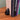 Black bookend holding up books on a wooden surface with a gray background