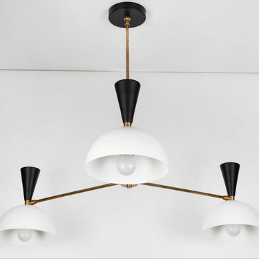 Modern chandelier with white shades and black accents on a white background
