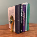 Stack of books on a wooden surface with a neutral background