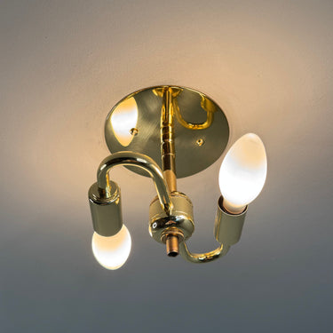 Gold wall-mounted light fixture with 2 bulbs on a gray background